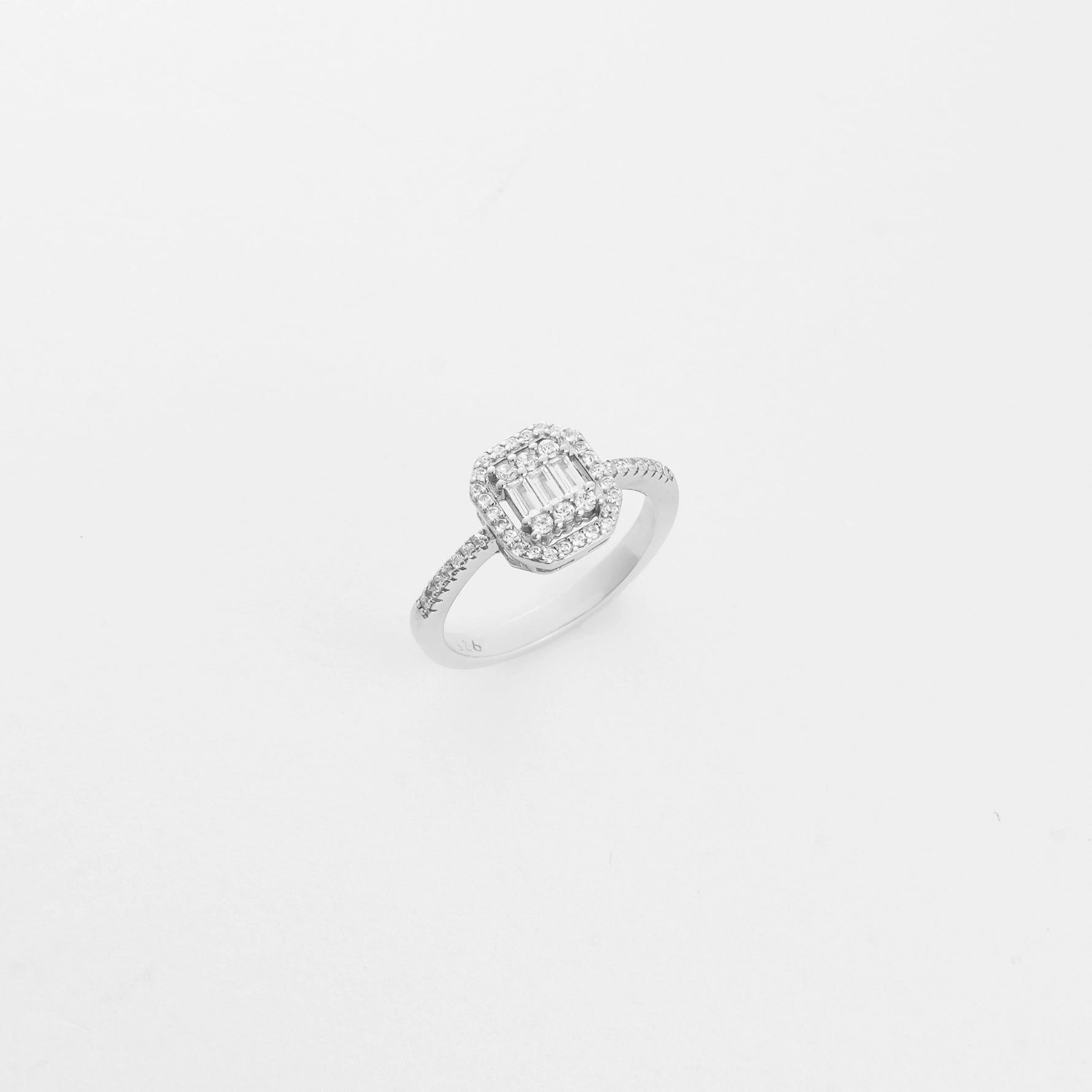 The Illusion Silver Ring showcases a rectangular center made of baguette-cut zircons, framed by two rows of sparkling round stones.