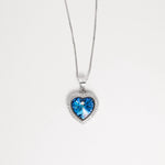 The Blue Heart Crystal Necklace is a stunning fine silver piece that captures the essence of elegance. At its center shines a brilliant blue heart-shaped crystal, surrounded by sparkling zircon stones that add a radiant glow.
