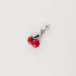 Crafted from fine silver, this charming pendant captures the delightful essence of juicy cherries with vibrant red and green details