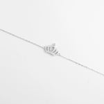 The Crown Bracelet is a delicate fine silver piece featuring a sparkling crown adorned with shimmering zircon stones.