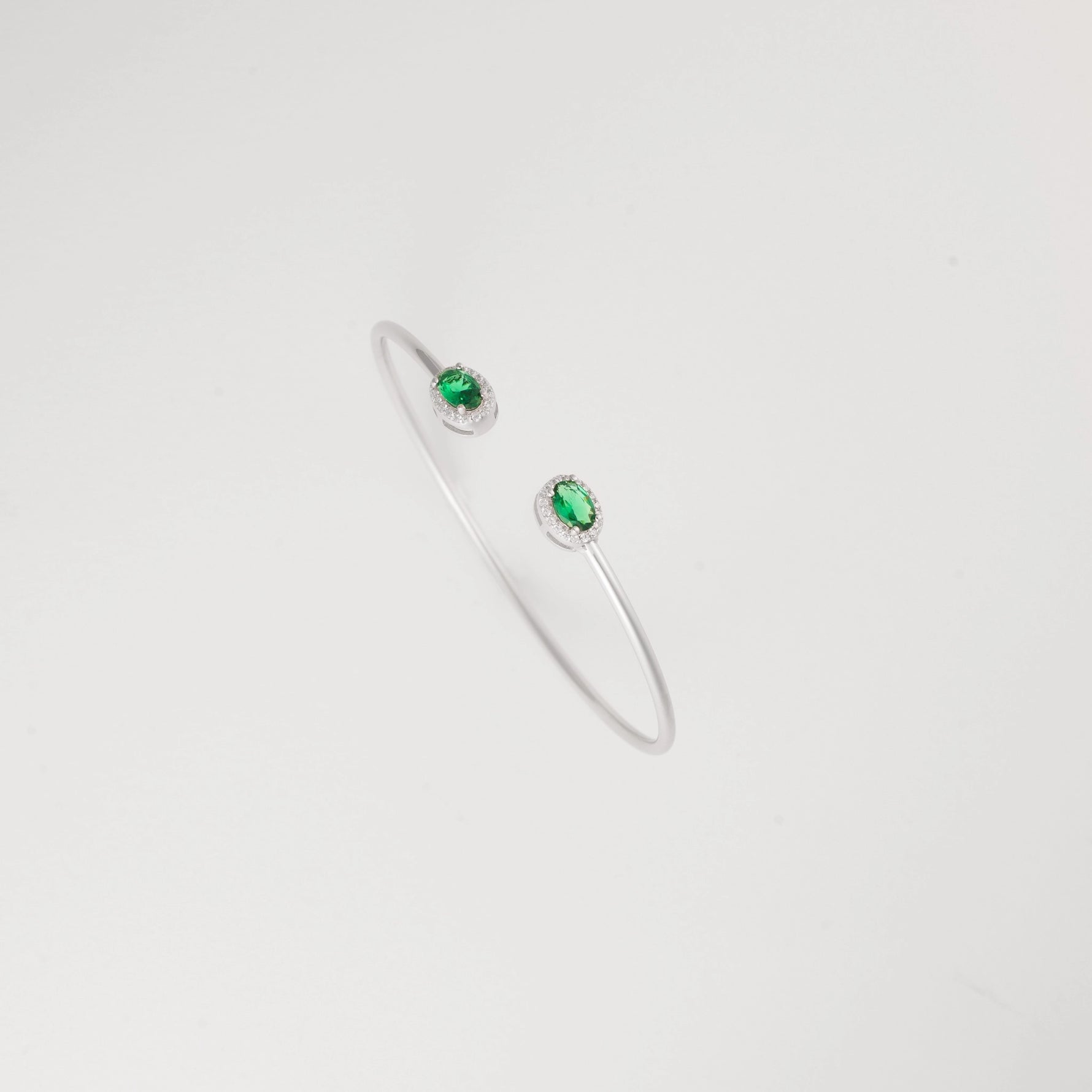Emerald Glow Silver Bangle, featuring radiant green crystal stones and delicate zircon halos.