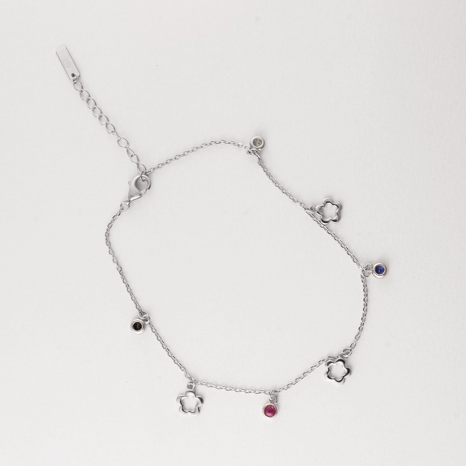 Fresh, fun, and full of summer charm the Flower Gem Anklet brings playful vibes to your sunny days. Made from fine silver, this anklet features dainty flower outlines and colorful mini stones in pink, black, blue, and clear tones.