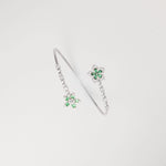 The Green Aura Bangle captures the essence of elegance with its twin floral designs, set in vivid emerald-toned stones and framed by radiant zircon accents.
