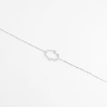 The Hamsa Glow Bracelet showcases a unique abstract charm traced with dazzling zircon stones.