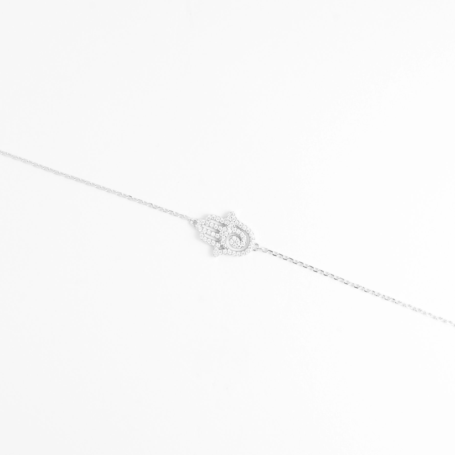 The Hamsa Hand Bracelet features a beautifully detailed charm shaped like the iconic protective hand, encrusted with bright zircon stones and a crystal eye at the center.