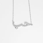The Hob Necklace is a graceful blend of fine silver and sparkling zircon stones, crafted to highlight the beauty of its Arabic calligraphy design.