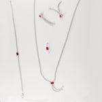 This set features a graceful necklace with cascading zircon stones and a bold red crystal center, paired perfectly with a matching bracelet, sleek ring, and dramatic drop earrings. The contrast of red and white stones adds a modern twist to classic sparkle, perfect for evening wear.