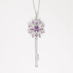 The Key to Elegance Necklace is a beautifully crafted piece in fine silver, featuring a delicate key pendant adorned with shimmering zircon stones and sparkling purple crystals.