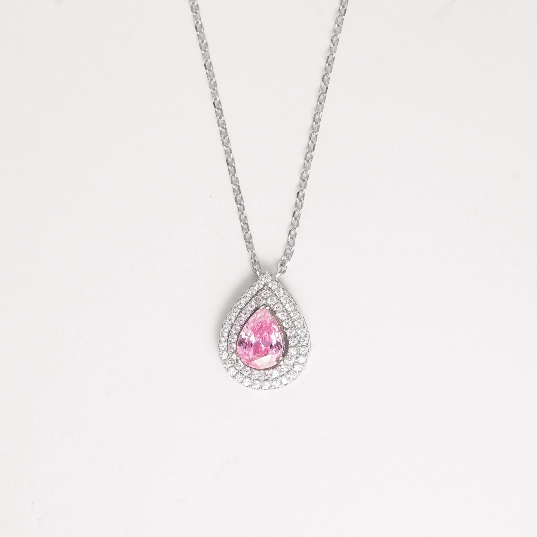 The Pink Drop Stone Necklace is a stunning piece that radiates soft elegance and feminine charm. Crafted from fine silver and surrounded by sparkling zircon stones, its delicate pink centerpiece captures the light beautifully.