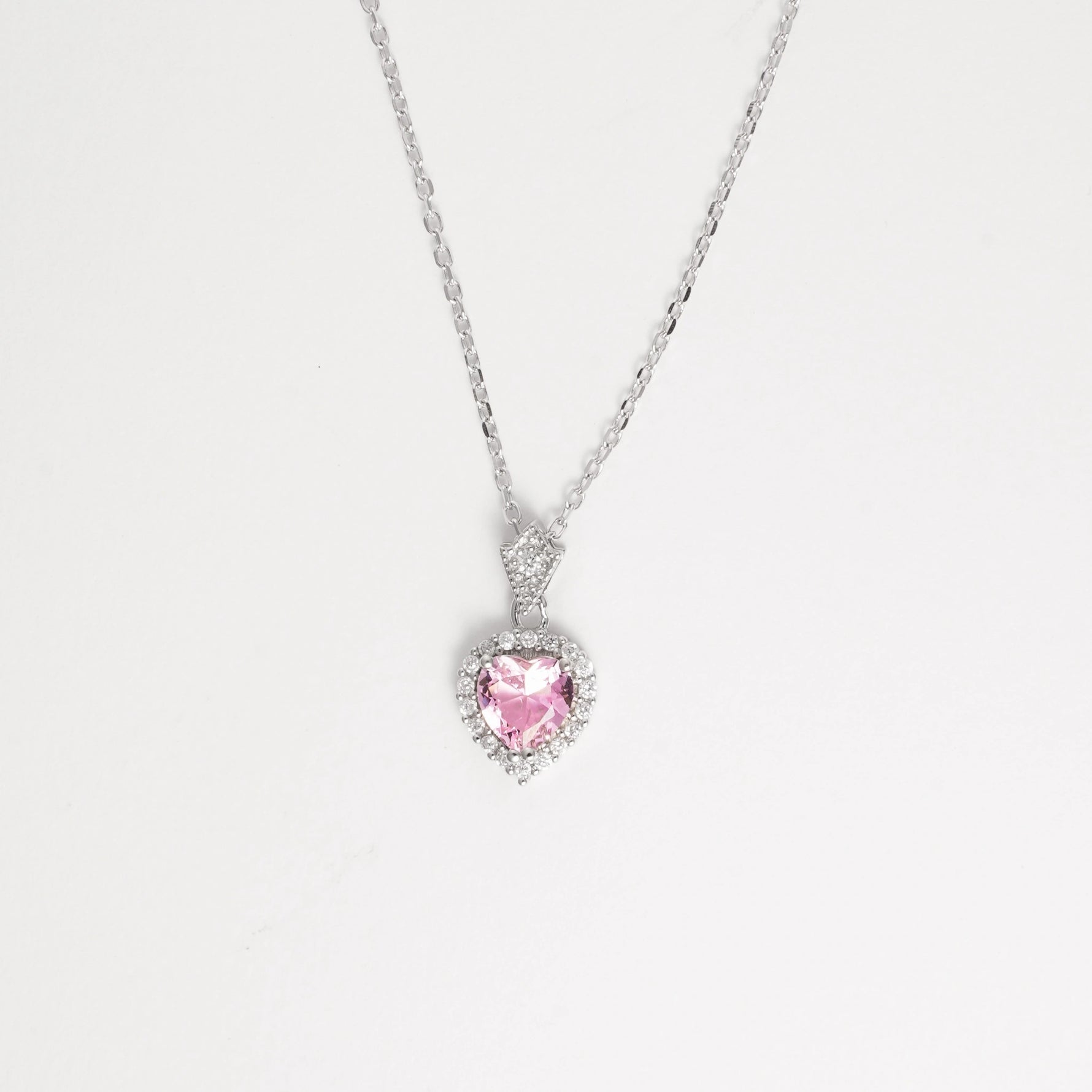 Delicate yet radiant, the Pink Heart Necklace ;is crafted in fine silver and features a soft pink heart-shaped crystal at its center, beautifully encircled by brightening zircon stones.
