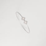 this silver Twilight Clover bangle features two elegant floral clover motifs outlined with dazzling zircon stones.