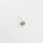 The Emerald Drop ring features a genuine green emerald stone gently cradled in a curved silver setting.