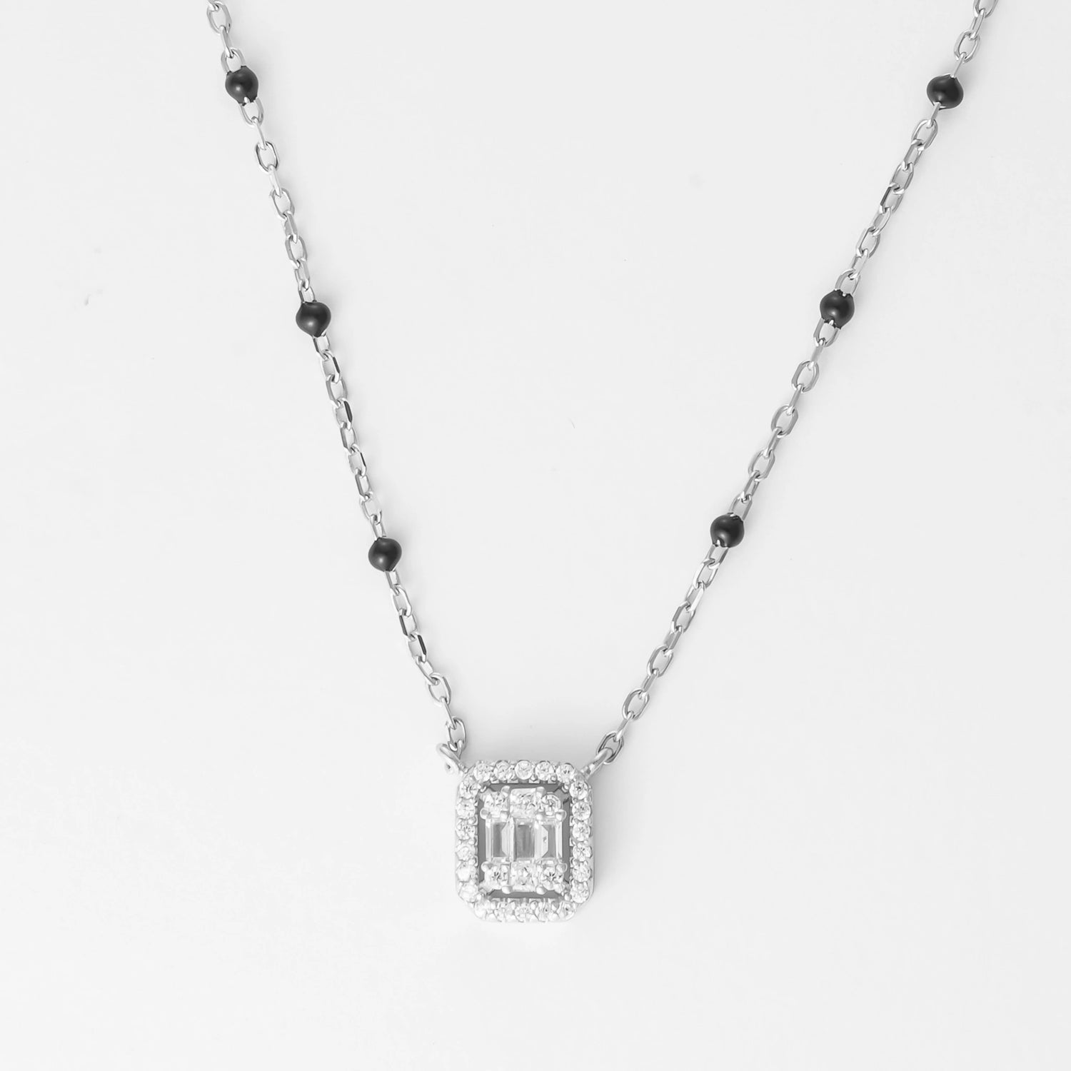  Crafted from fine silver, this piece features a sparkling halo pendant framed by subtle black beads along the chain, adding a modern twist to classic elegance. 
