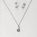 Elegant with a hint of mystique, the Blue Evil Eye Half Set brings protection in one refined design. Crafted from fine silver and accented with sparkling zircon stones, the round pendant and matching earrings feature the iconic evil eye symbol in tones of sky blue, black, and white. 