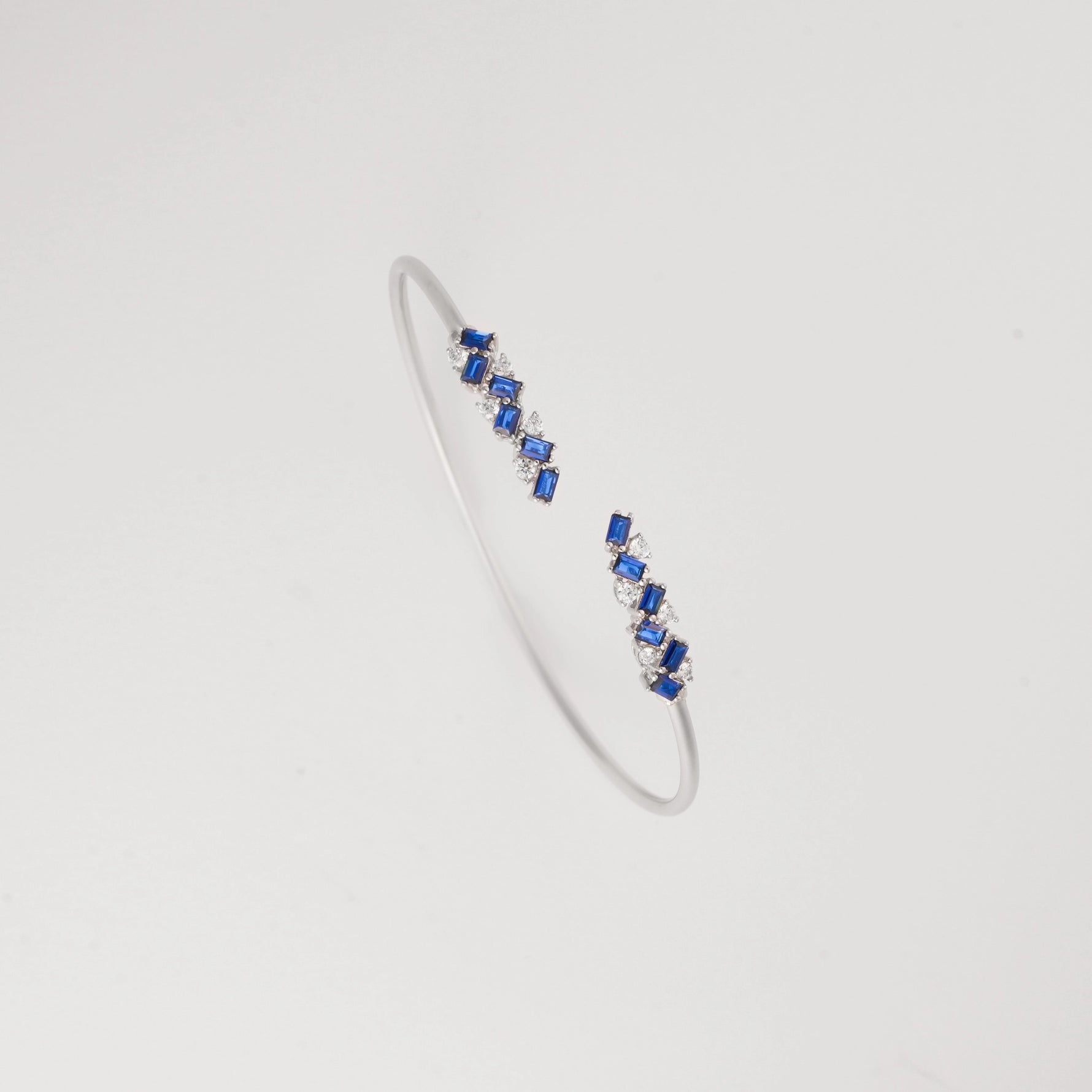 Add a pop of elegance with the Blue Mirage Silver Bangle. Adorned with vibrant blue crystal stones and sparkling zircons, it’s a perfect mix of bold and refined style.