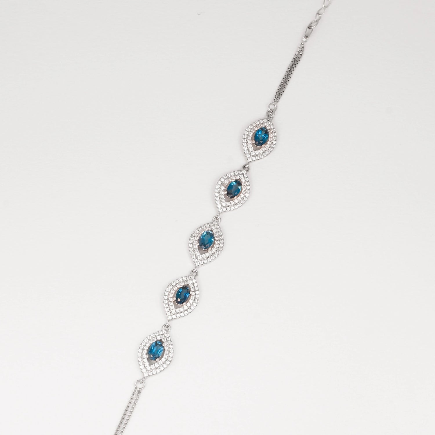 Discover the elegance of the Blue Topaz Bracelet, crafted with fine silver and real blue topaz stones. Each stone is surrounded by sparkling zircon accents, creating a stunning contrast that catches the light beautifully.