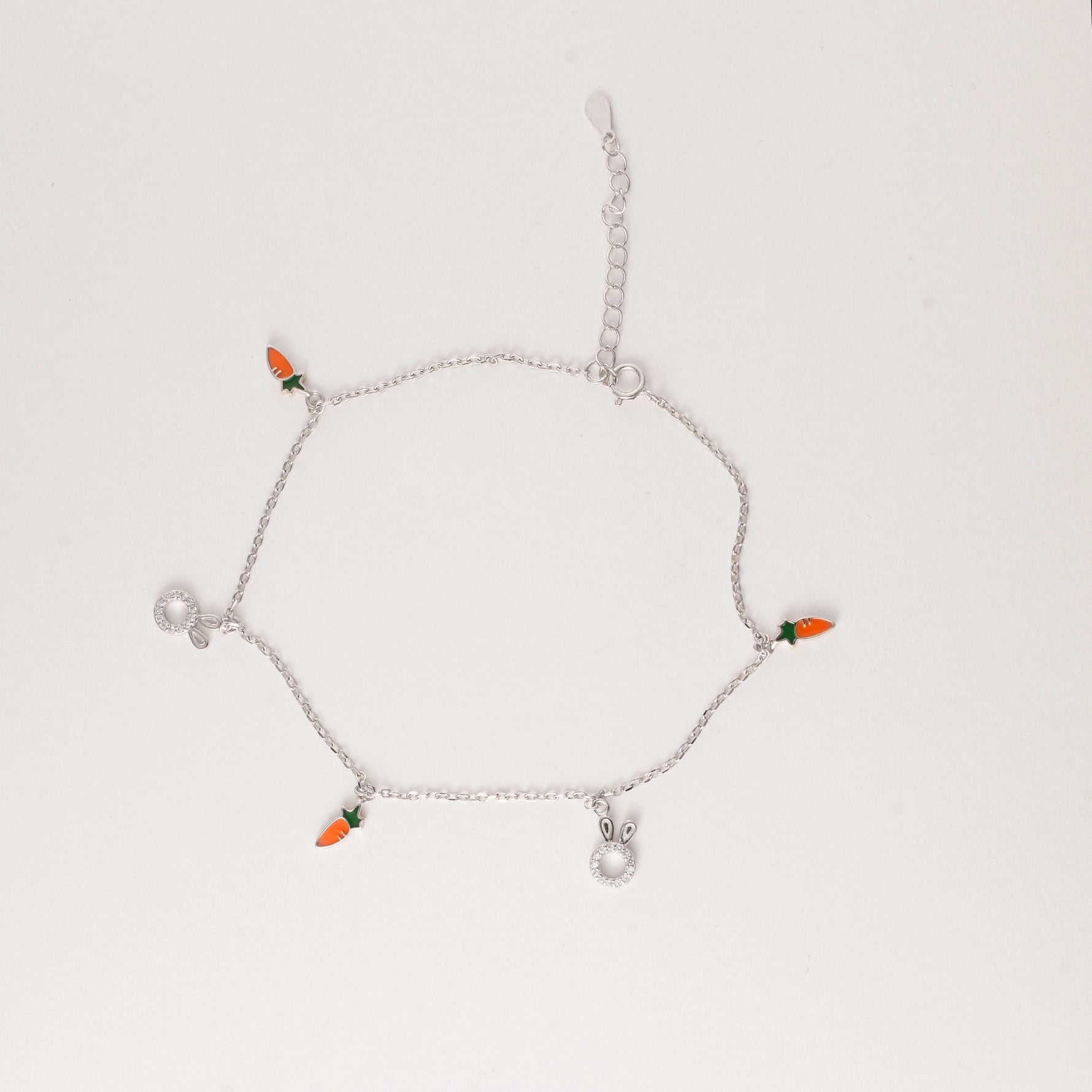 Playful, fresh, and made for sunshine days. The Carrot Bunny Anklet features a fine silver chain with tiny orange carrot charms and adorable crystal-studded bunny heads.