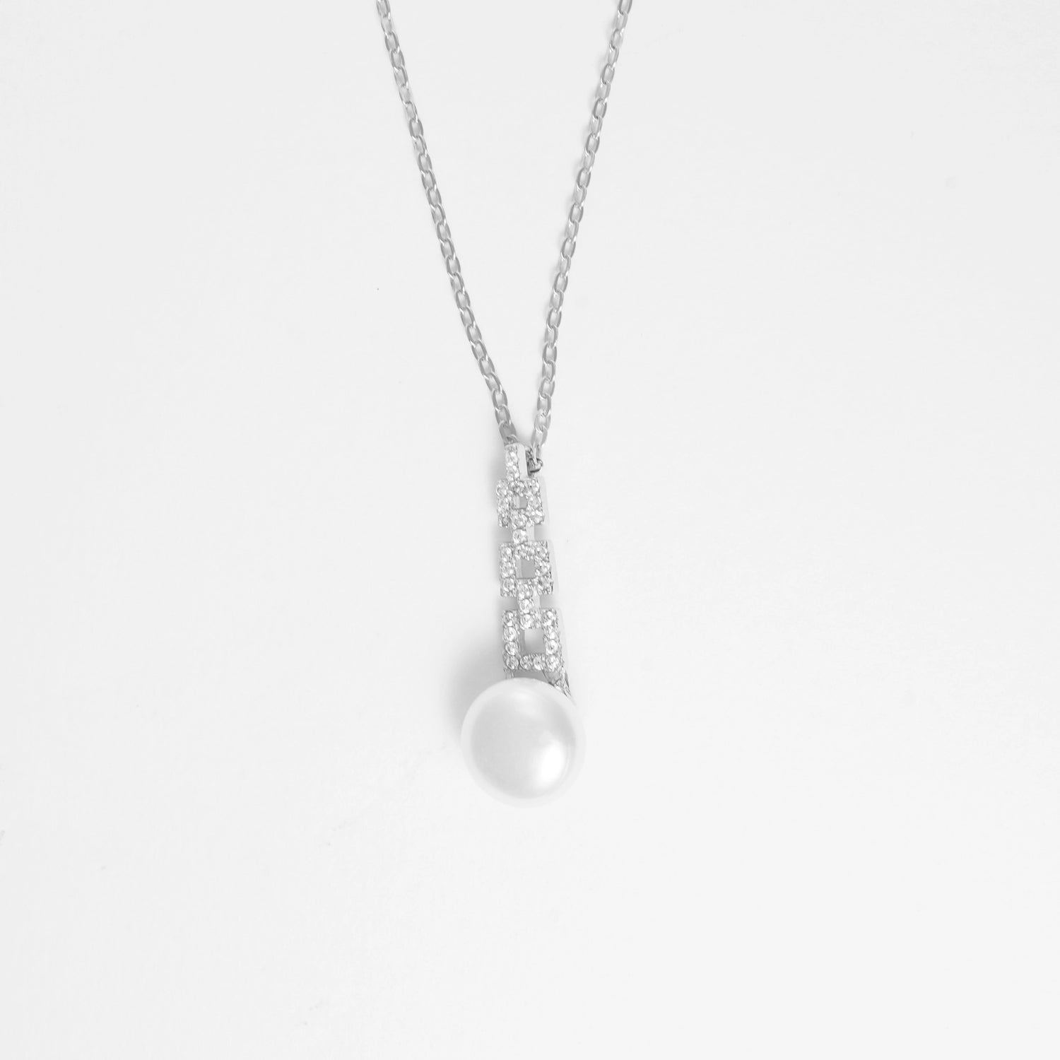 The Classic Pearl Necklace is a timeless piece crafted from fine silver and sparkling zircon stones. Its elegant design features a specular pearl-like charm that adds a touch of sophistication to any outfit.