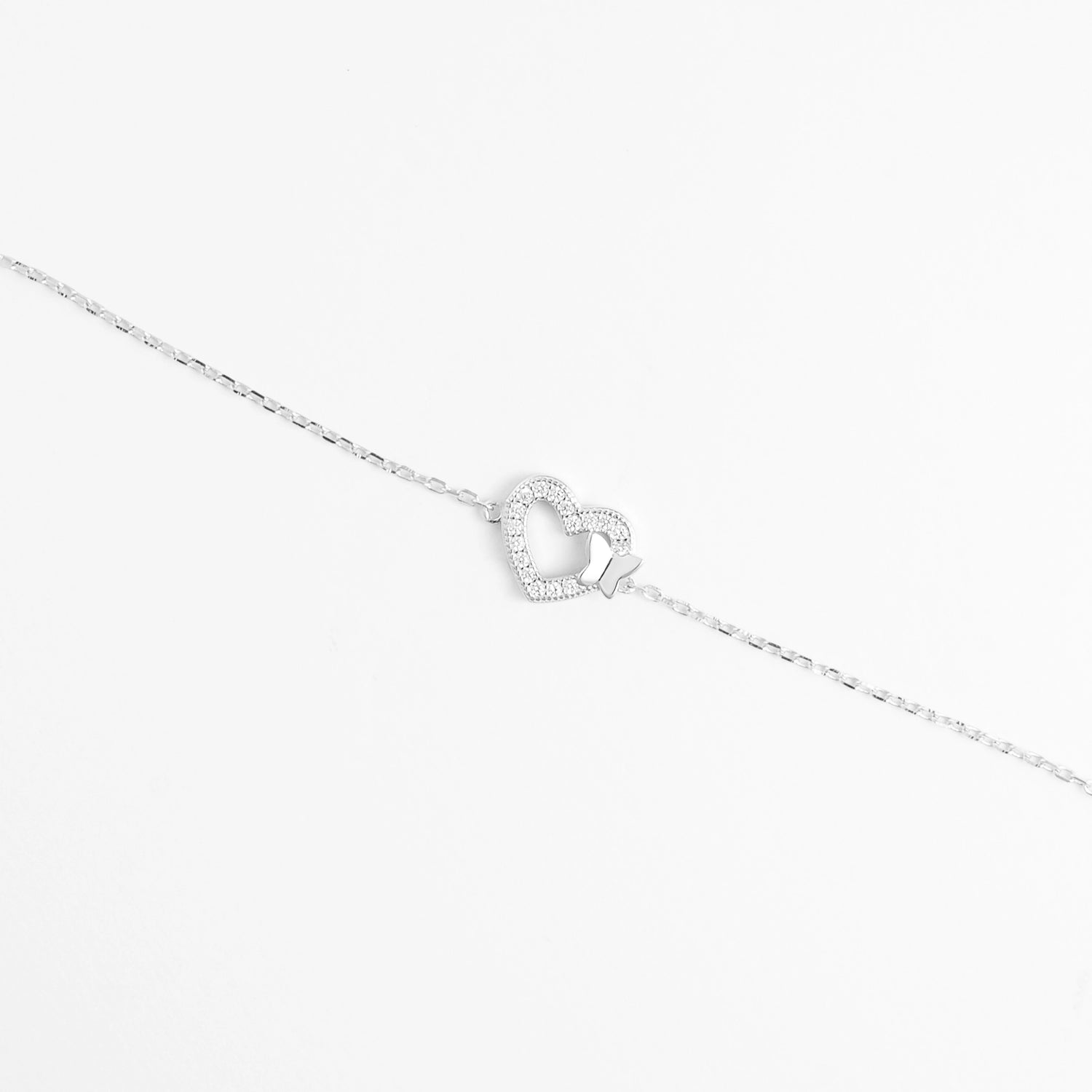 The Butterfly Heart Bracelet features a graceful heart outline adorned with sparkling zircon stones, gently touched by a tiny butterfly charm.
