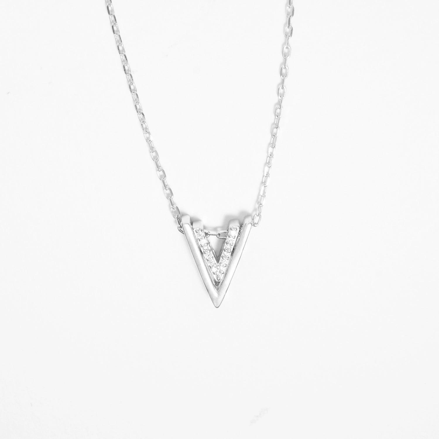 Bold yet minimal, the Double V Pendant Necklace brings effortless edge to your look. Crafted in pure silver, it features a sharp V-shape lined with bright zircon stones that add a clean sparkle.