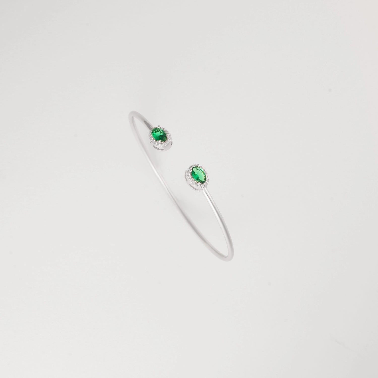 Emerald Glow Silver Bangle, featuring radiant green crystal stones and delicate zircon halos.