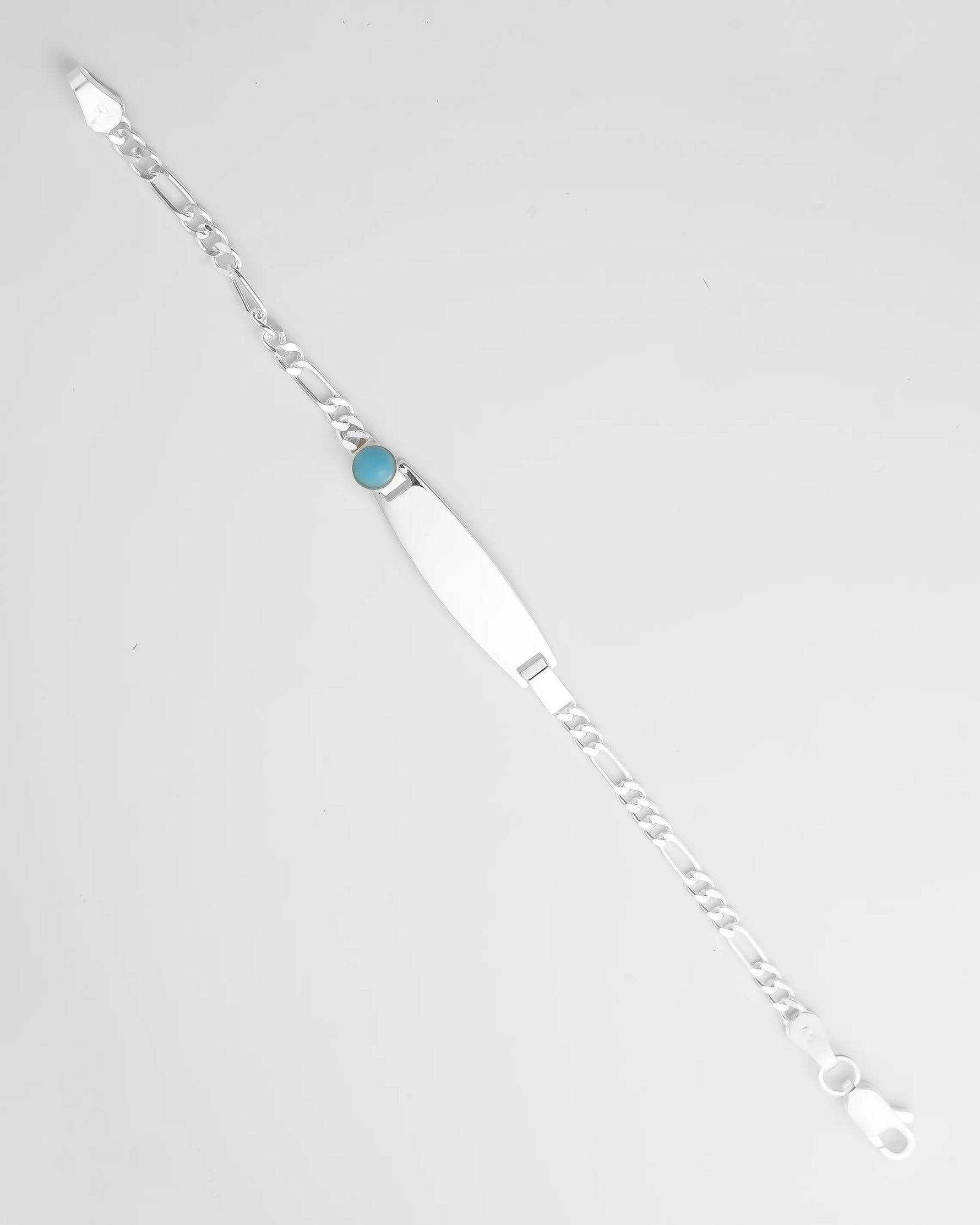 Silver bracelet with a blue gemstone on a light gray background for kids