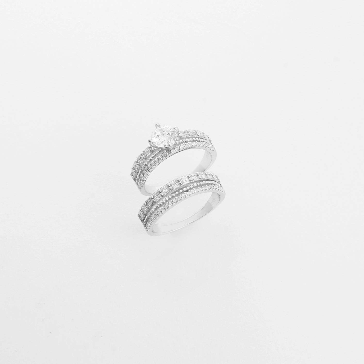The Eternal Bond Duo Twin ring set features two beautifully crafted silver bands—one crowned with a radiant center stone, the other fully lined with bright zircon stones. 