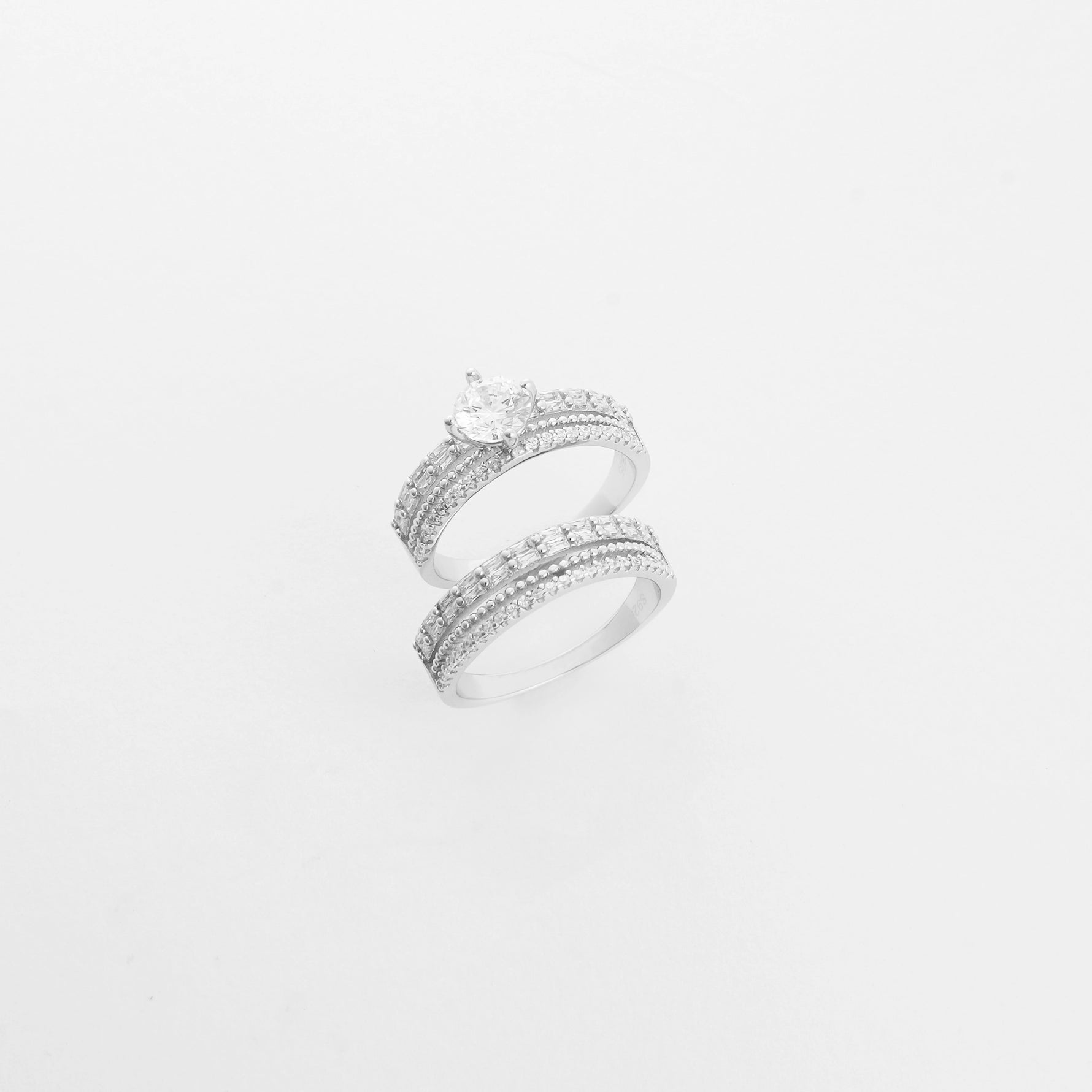 The Eternal Bond Duo Twin ring set features two beautifully crafted silver bands—one crowned with a radiant center stone, the other fully lined with bright zircon stones. 
