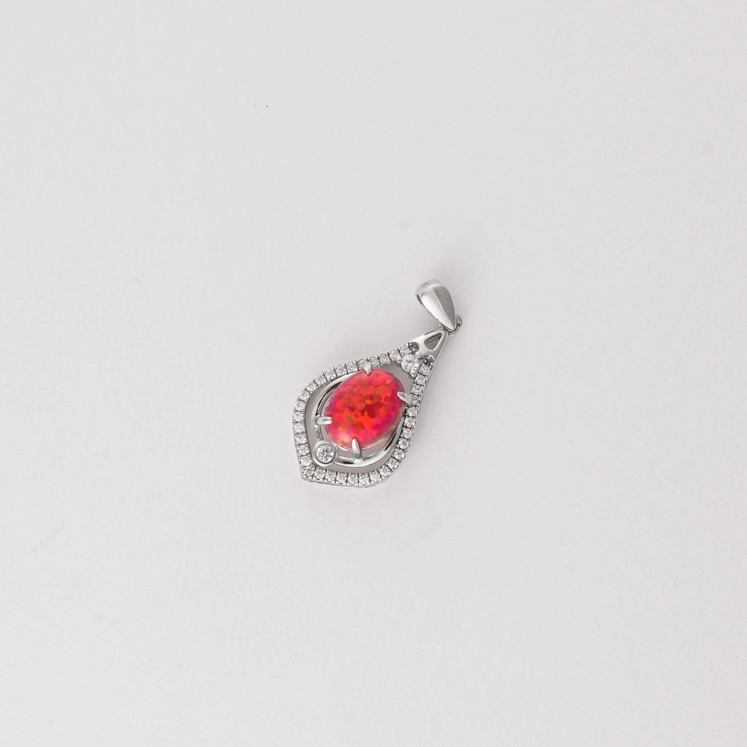 Bold and unforgettable, the Fiery Drop Pendant is made to stand out. Crafted from fine silver, it features a vibrant flame-like red stone that glows with energy and passion. Framed by a halo of bright zircon stones, this teardrop-shaped pendant adds a spark of elegance to any summer outfit.