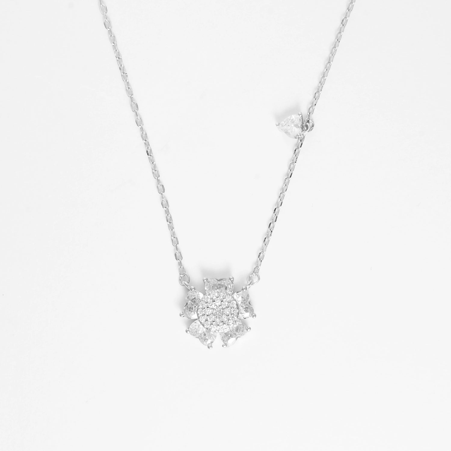 The Floral Cluster Necklace is a stunning blend of fine silver and brightening zircon stones, designed to capture the delicate beauty of a blooming flower.