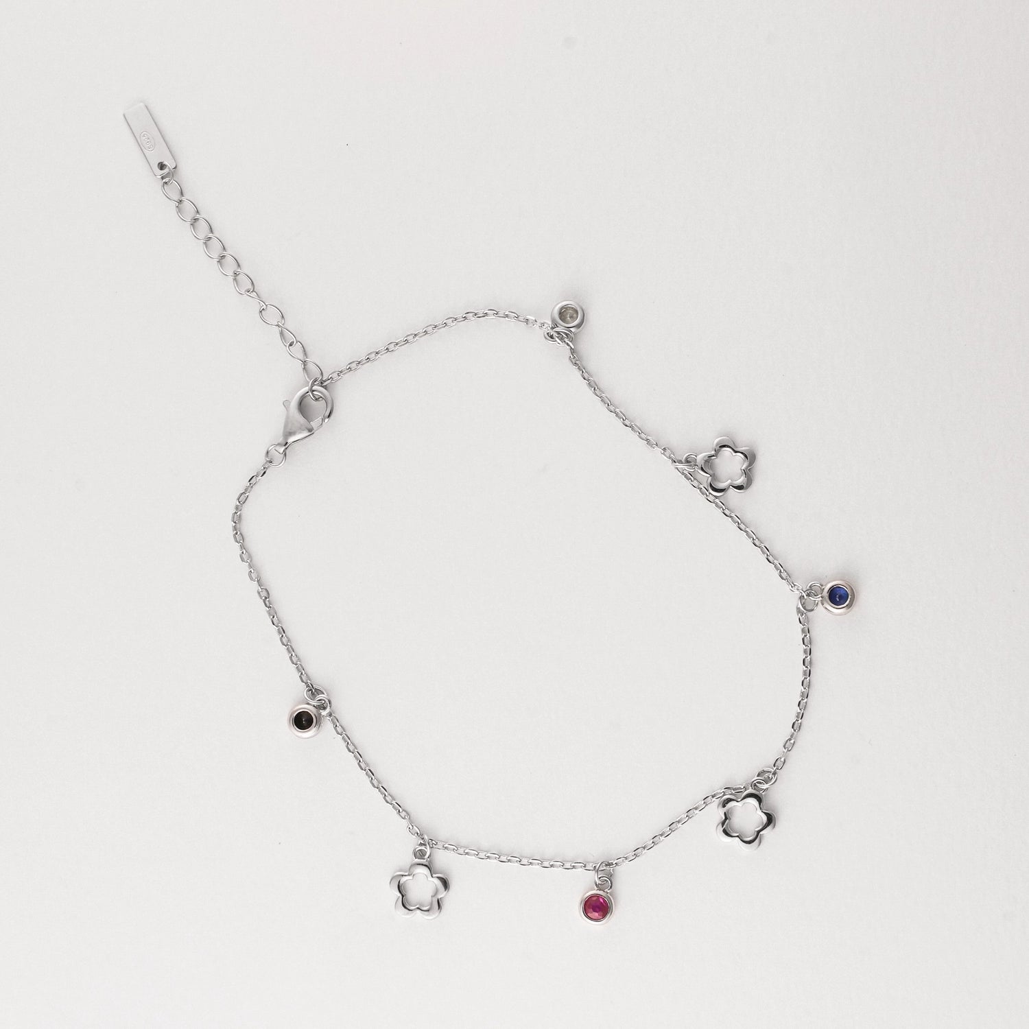 Fresh, fun, and full of summer charm the Flower Gem Anklet brings playful vibes to your sunny days. Made from fine silver, this anklet features dainty flower outlines and colorful mini stones in pink, black, blue, and clear tones.