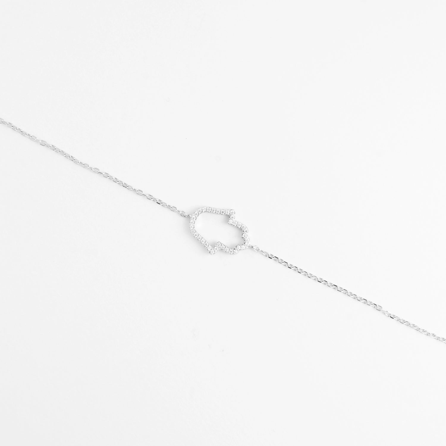 The Hamsa Glow Bracelet showcases a unique abstract charm traced with dazzling zircon stones.