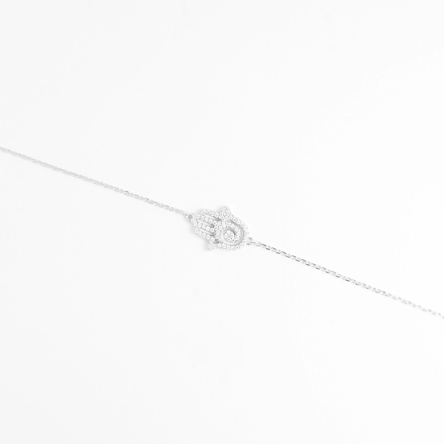 The Hamsa Hand Bracelet features a beautifully detailed charm shaped like the iconic protective hand, encrusted with bright zircon stones and a crystal eye at the center.