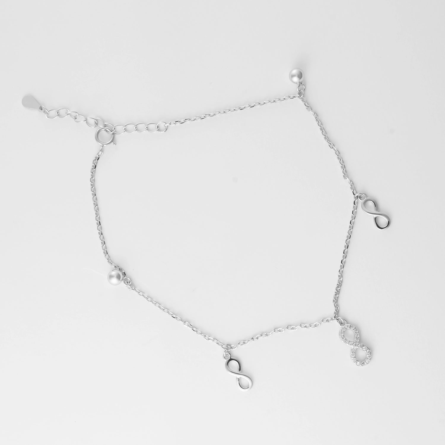 Celebrate endless summer days with the Infinity Pearl Anklet. Made from fine silver, this delicate anklet features elegant infinity charms—one accented with shimmering stones—paired with soft silver beads.
