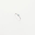 The Opal Accent Ring is a delicate fine silver piece that sparkles with a beautiful opal stone at its center.
