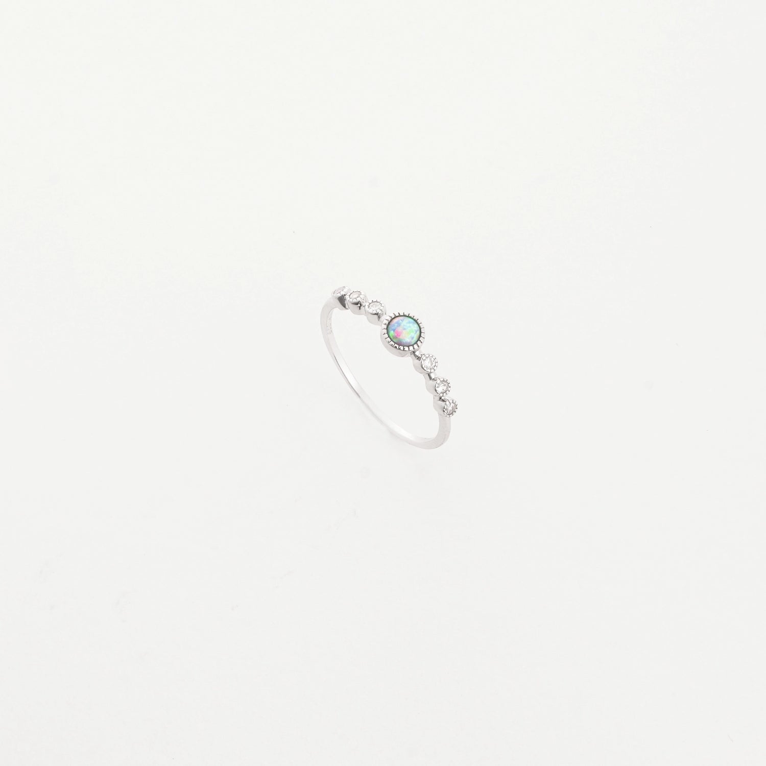 The Opal Accent Ring is a delicate fine silver piece that sparkles with a beautiful opal stone at its center.
