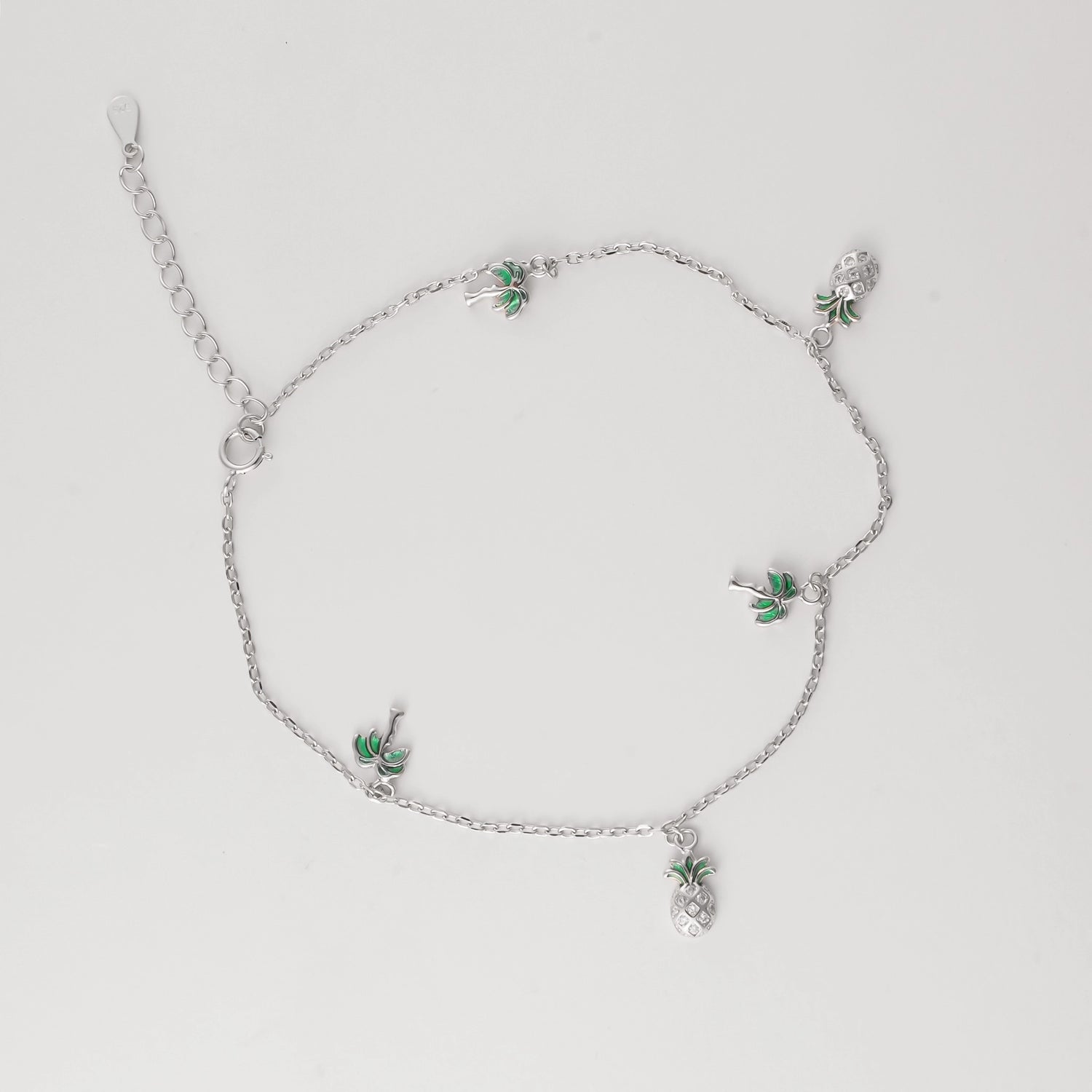 Bring the island spirit to your summer look with the Pineapple Palm Anklet. Made from fine silver, this playful piece features tiny palm tree and pineapple charms that swing with every step.