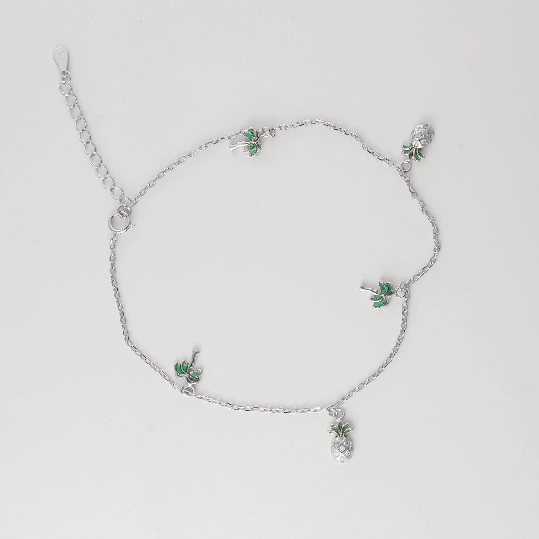 Bring the island spirit to your summer look with the Pineapple Palm Anklet. Made from fine silver, this playful piece features tiny palm tree and pineapple charms that swing with every step.
