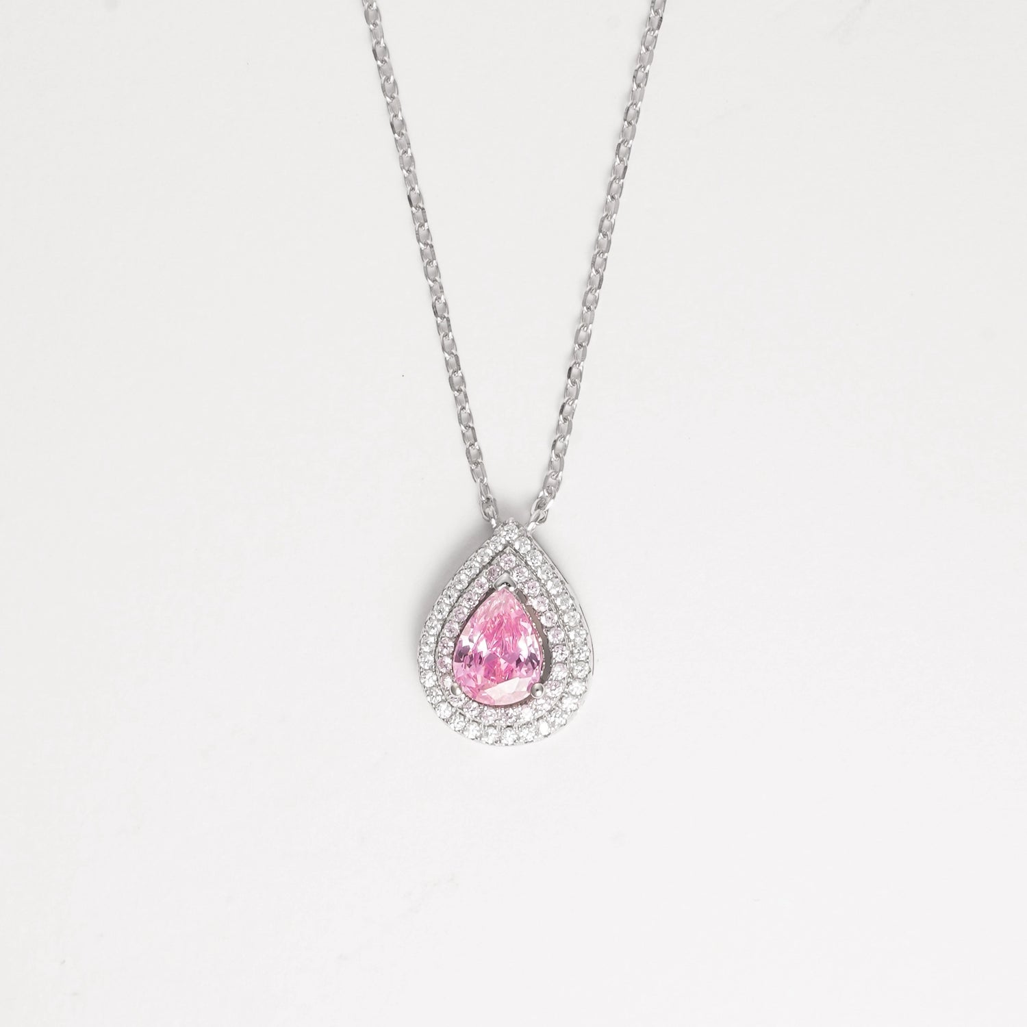 The Pink Drop Stone Necklace is a stunning piece that radiates soft elegance and feminine charm. Crafted from fine silver and surrounded by sparkling zircon stones, its delicate pink centerpiece captures the light beautifully.