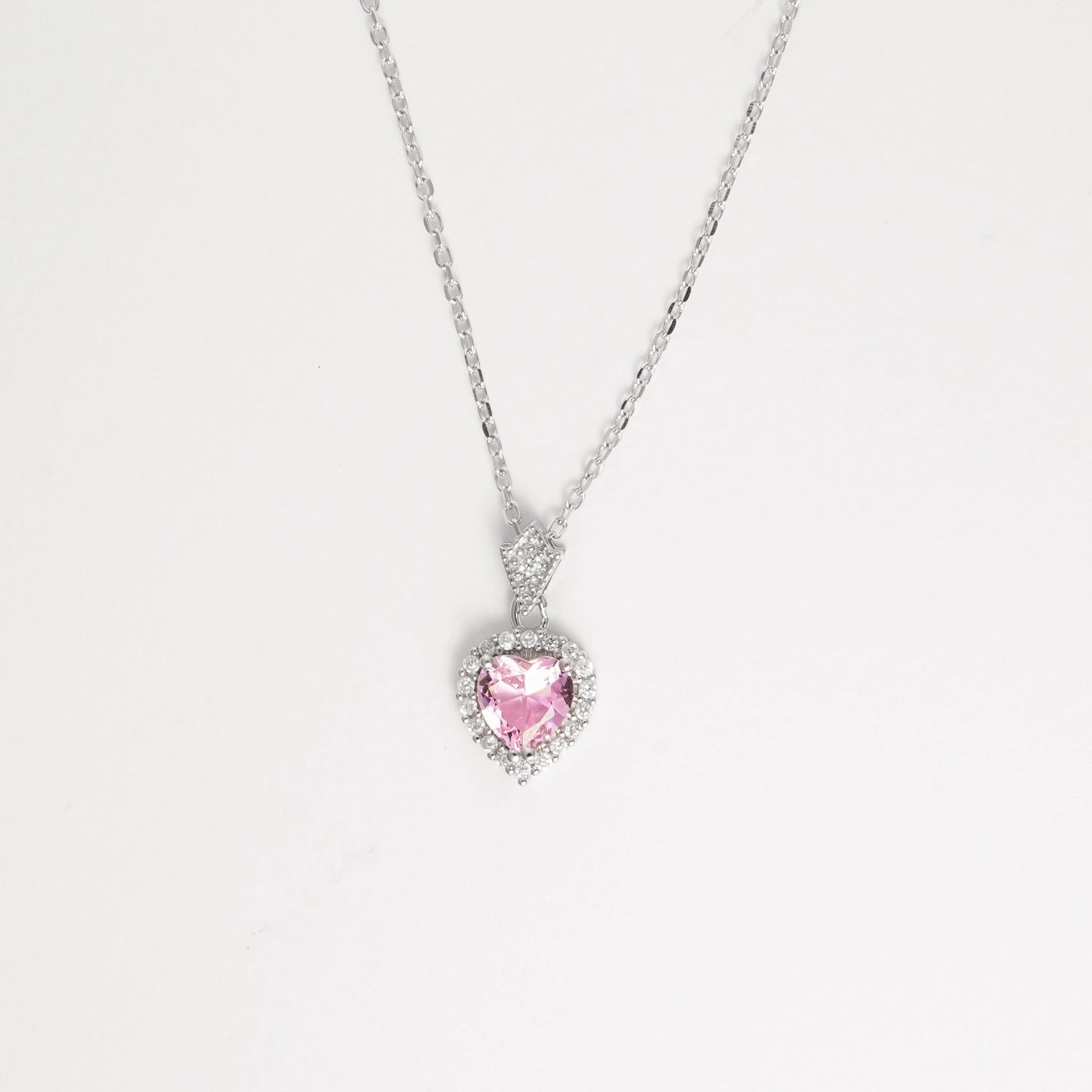 Delicate yet radiant, the Pink Heart Necklace ;is crafted in fine silver and features a soft pink heart-shaped crystal at its center, beautifully encircled by brightening zircon stones.