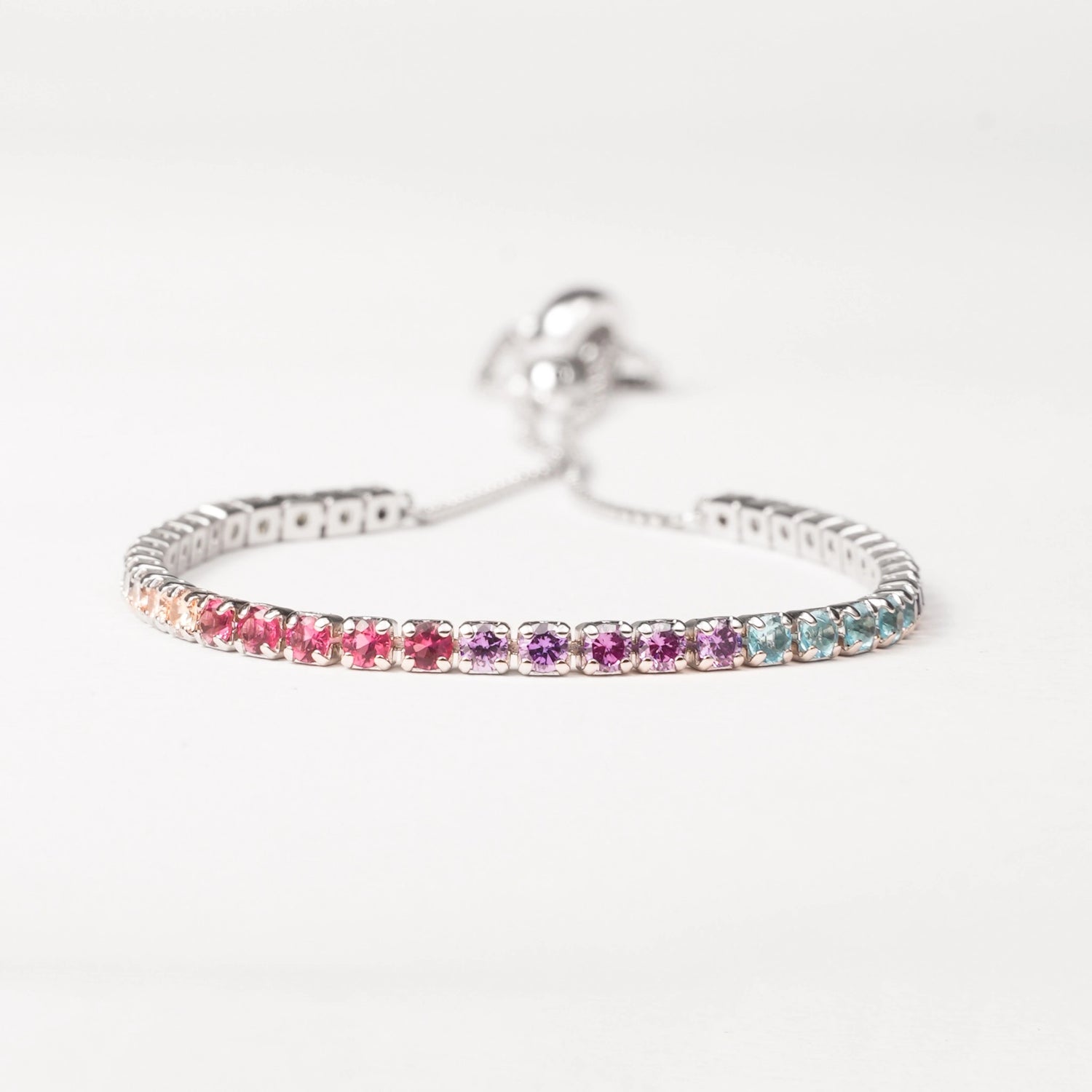 Brighten your look with the Rainbow Adjustable Tennis Bracelet. Crafted from fine silver and sparkling zircon stones in a beautiful spectrum of colors, this bracelet adds a playful yet elegant touch to any outfit.
