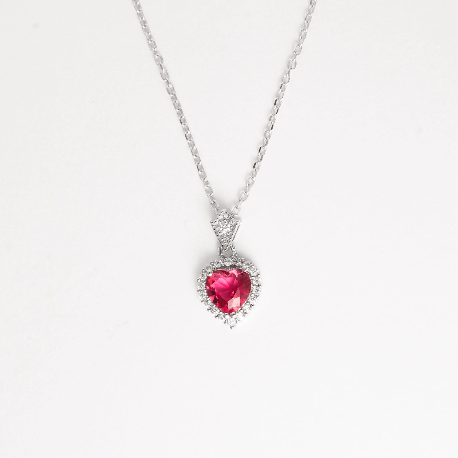 Elegant and full of charm, the Red Heart Necklace&nbsp;features a radiant heart-shaped red crystal set in fine silver. Surrounded by a halo of bright zircon stones, this design captures the light beautifully from every angle