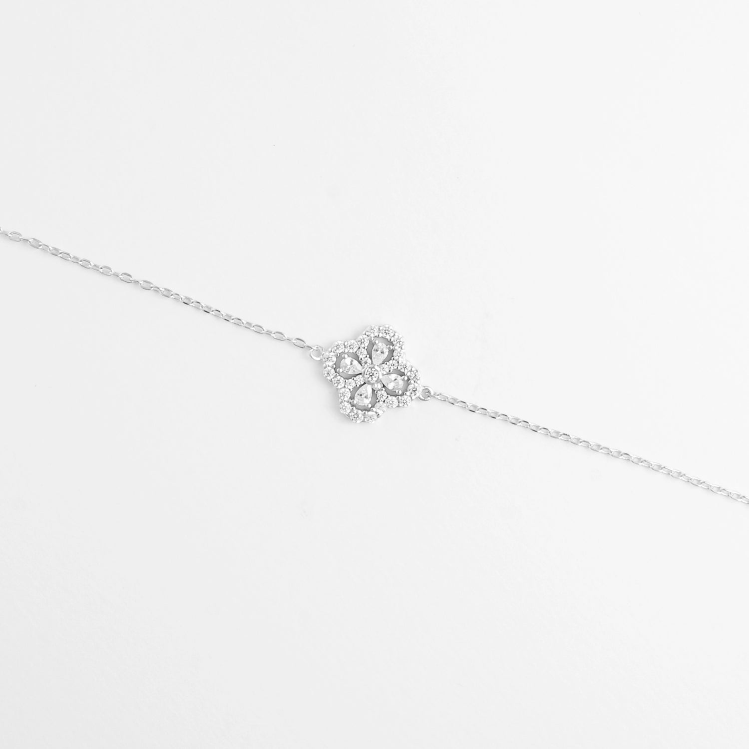 The Sparkly Clover Bracelet features a charming clover design made of pear-shaped zircon stones, surrounded by delicate crystal accents.