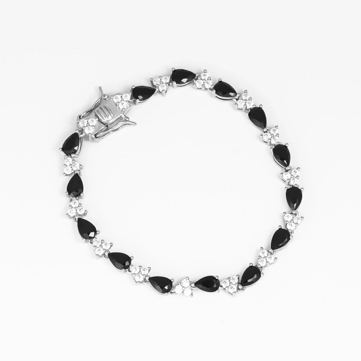 the Teardrop Black Tennis Bracelet, a stunning accessory crafted from fine silver and adorned with sparkling zircon stones. The unique teardrop-shaped black zircon stones alternate with bright clear zircons, creating a chic and elegant look.
