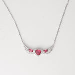 A symbol of love and elegance, the Triple Red Heart Wing Necklace features three dazzling pink heart crystals embraced by wing-like curves of shimmering zircon stones. Set in pure silver, its winged design brings a graceful lift to any look. A perfect blend of charm and sparkle made to brighten your neckline with every wear.