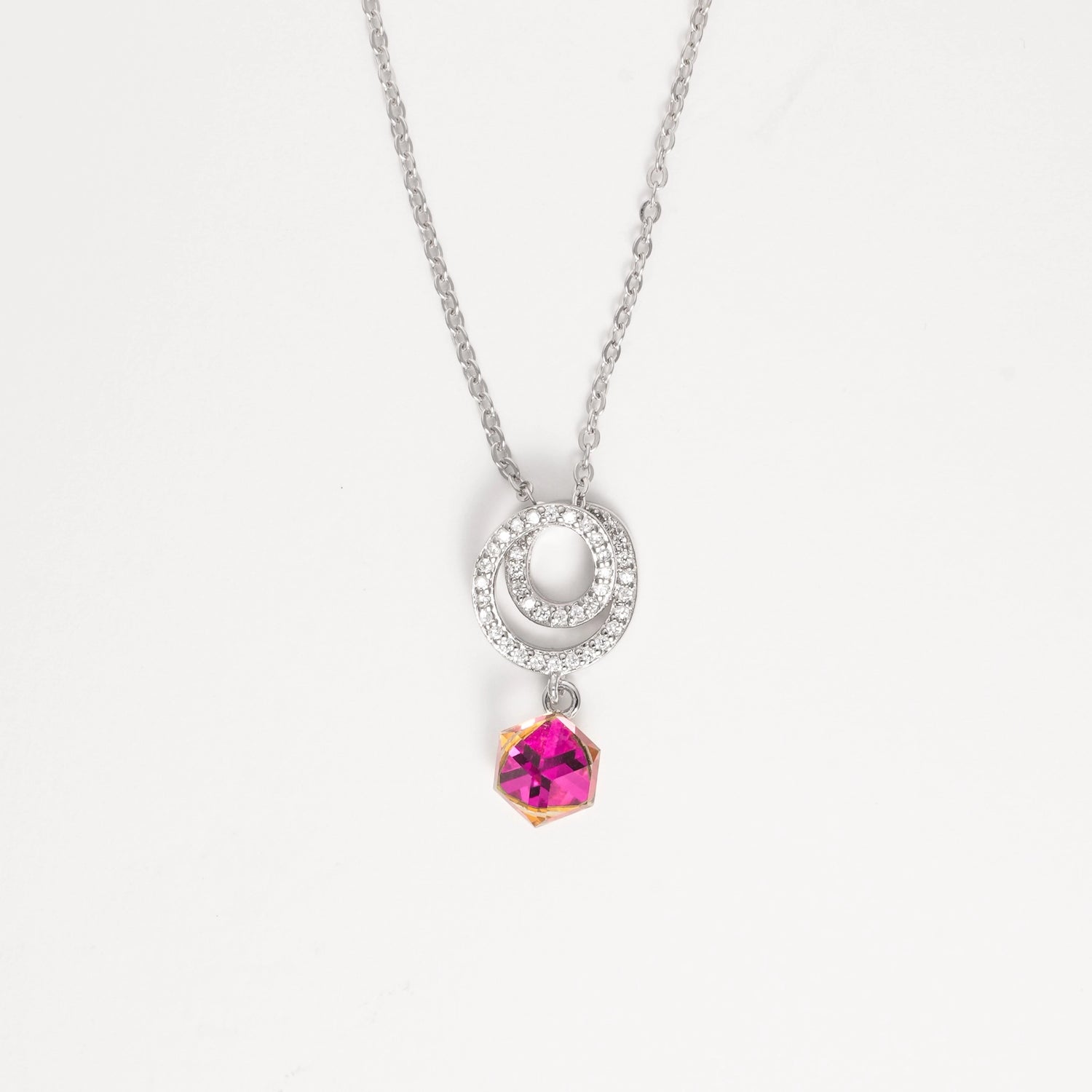 The Twilight Crystal Necklace captures the beauty of light and color in one elegant piece. Set in pure silver, its double halo sparkles with bright zircon stones, gently circling a magical crystal that shifts between pink, yellow, and clear tones—like twilight dancing on your skin.