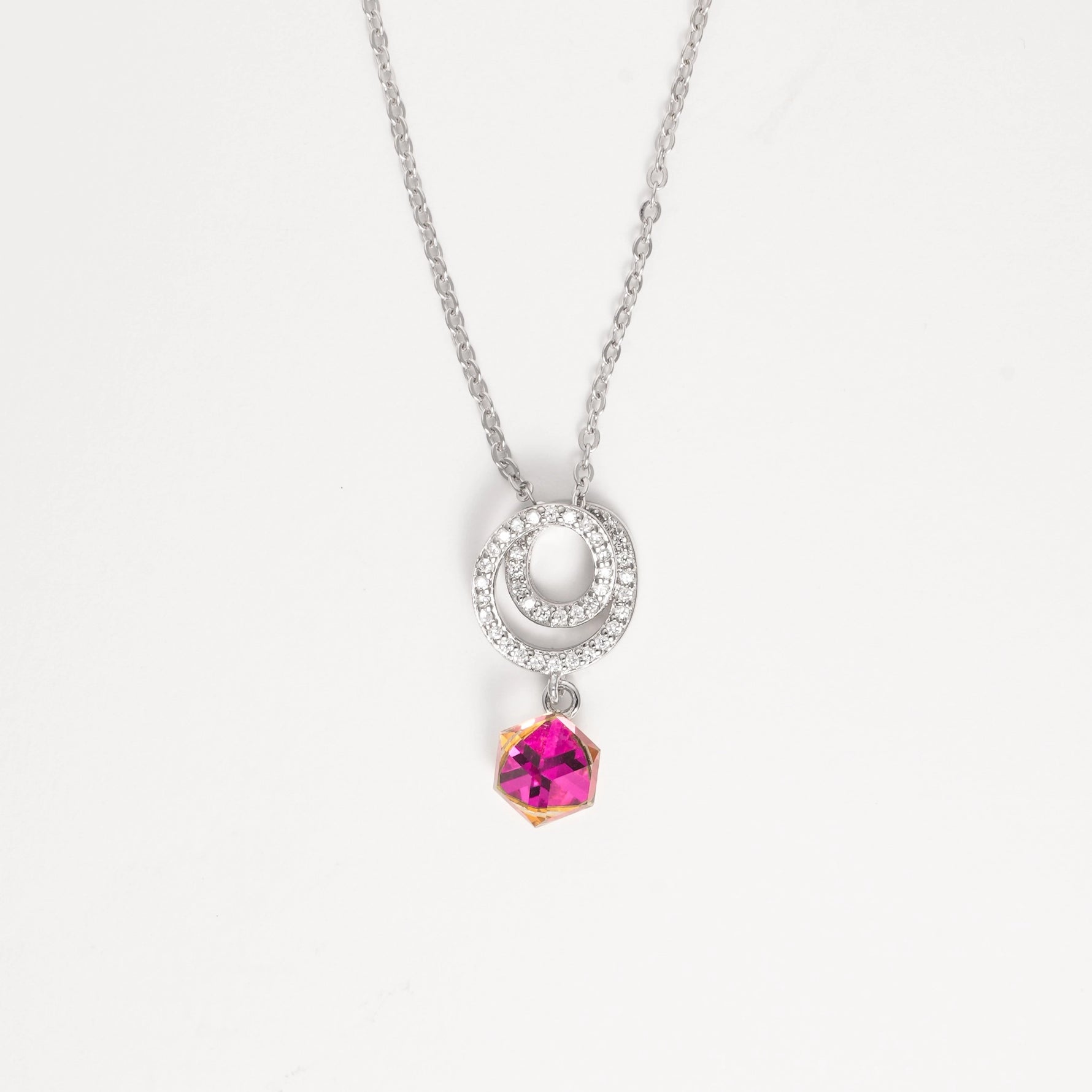 The Twilight Crystal Necklace captures the beauty of light and color in one elegant piece. Set in pure silver, its double halo sparkles with bright zircon stones, gently circling a magical crystal that shifts between pink, yellow, and clear tones—like twilight dancing on your skin.